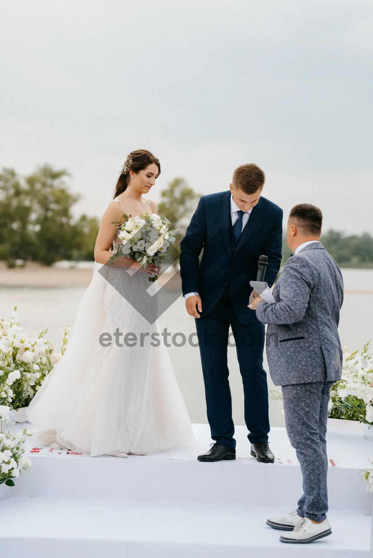 Picture of Happy couple celebrating wedding outdoors with flowers and smiles.