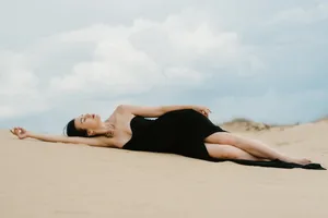 Attractive brunette model in bikini relaxing on sand