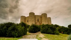 Medieval castle overlooking scenic historical landscape & sky.