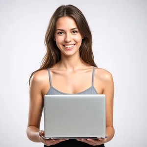 Attractive businesswoman smiling with laptop in casual setting.