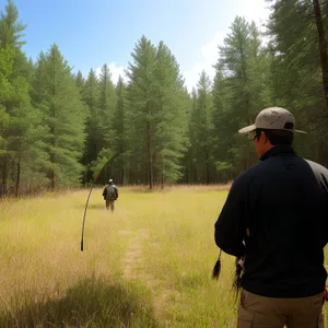 Adventurous hiker with bow and arrow in scenic mountain landscape