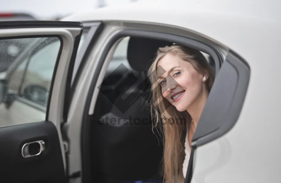 Picture of Attractive adult driving a car with happy smile.