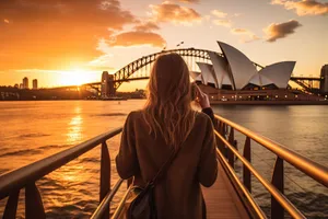 Silhouette of person on bridge at sunset.