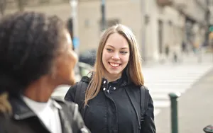 Confident professional businesswoman smiling outdoors in portrait shot.