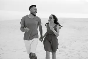 Happy family walking on the tropical beach shore