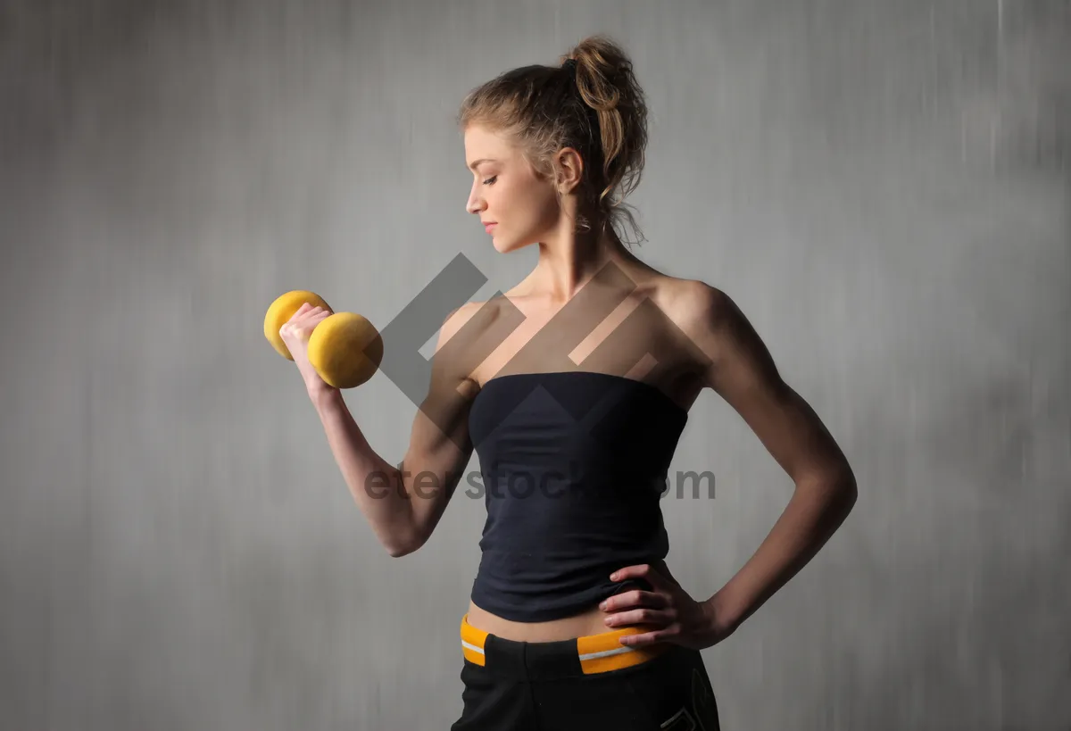 Picture of Happy person exercising with dumbbell and apple