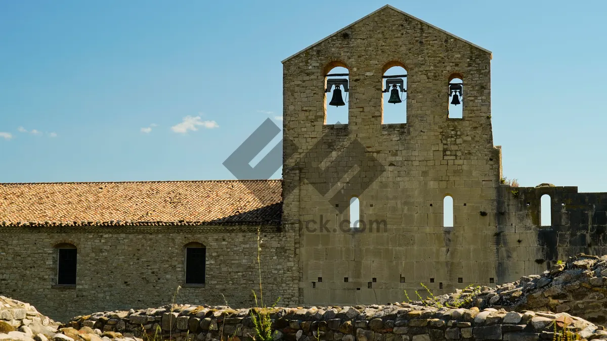 Picture of Medieval castle with bell tower and stone walls.