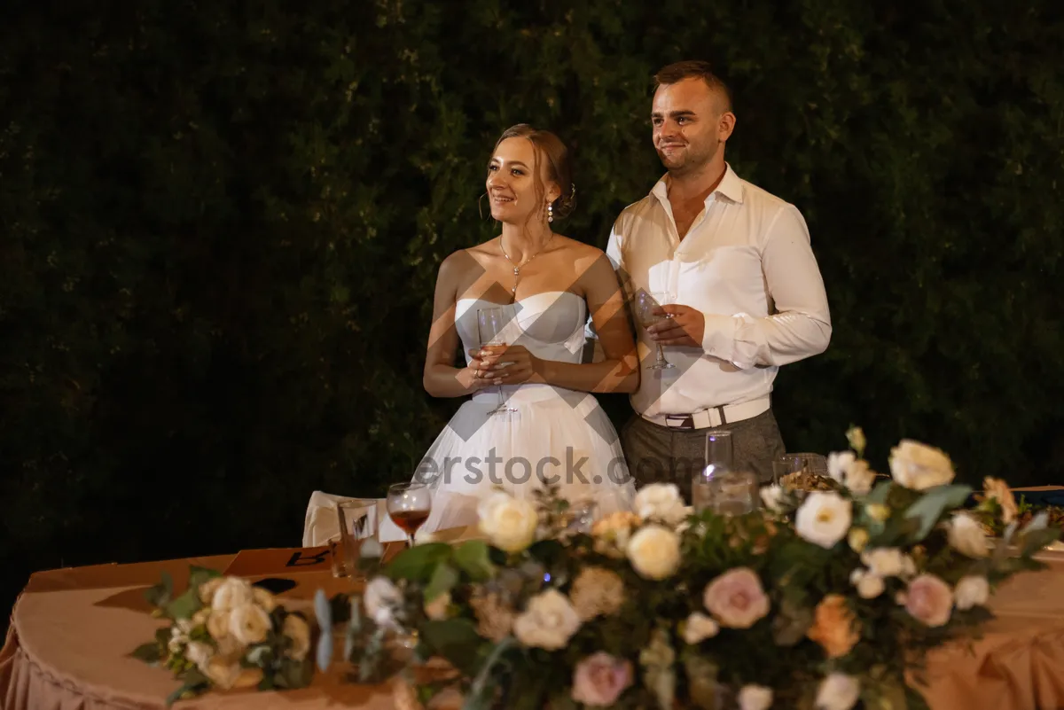 Picture of Happy couple outdoors on wedding day smiling together.