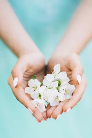 Pink flower in bride's hand, symbolizing purity