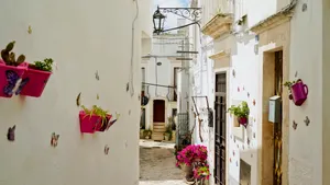 Old town building with stone walls and balcony.