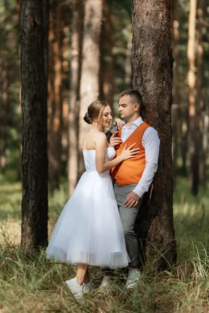 Happy couple celebrating wedding outdoors in summer with flowers.