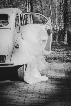 Happy newlywed couple under umbrella on their wedding day.