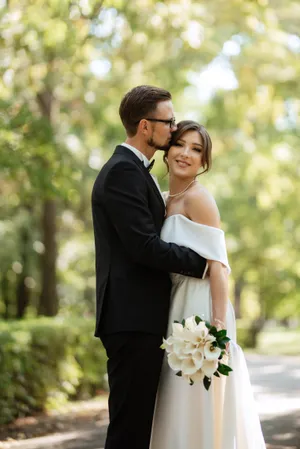 Happy newlywed couple smiling outdoors on their wedding day