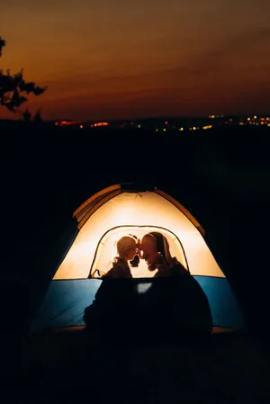 Silhouette tent against mountain backdrop.