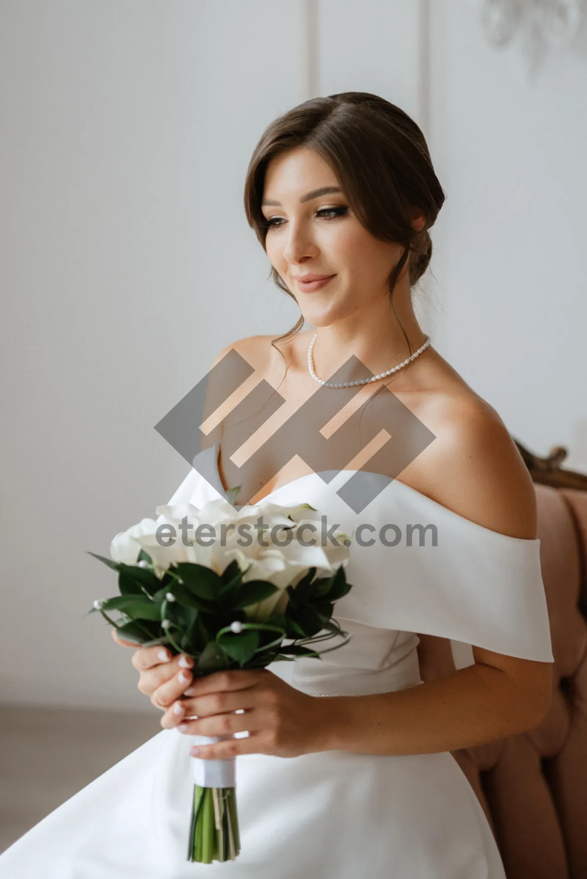 Picture of Attractive bride in elegant gown with flower bouquet