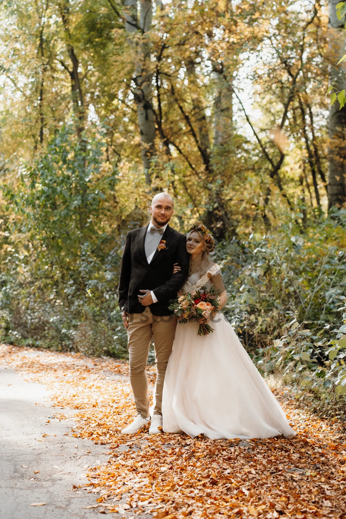 Picture of Happy couple embracing on wedding day in park