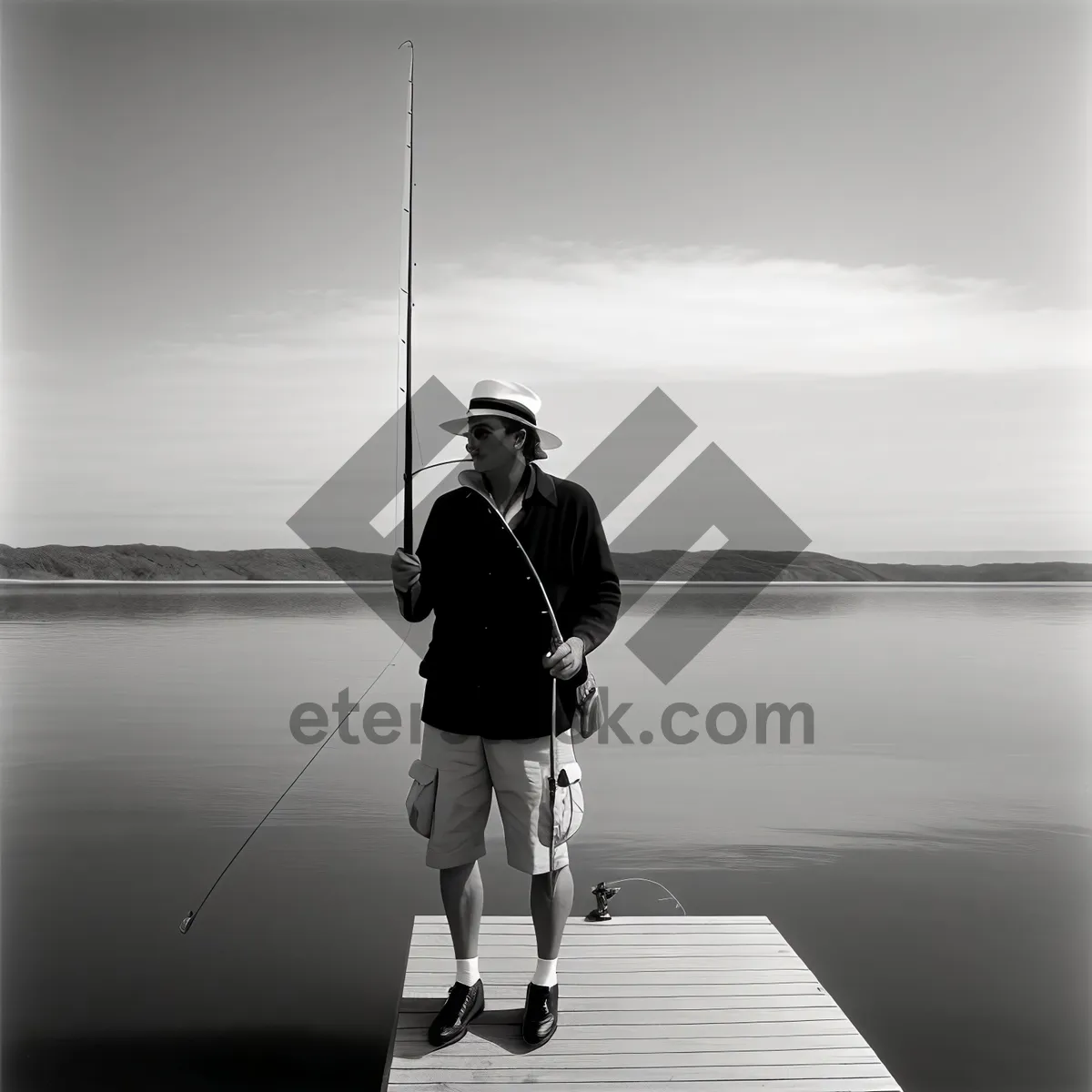 Picture of Sunset Fisherman Reeling in Catch on Beach