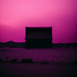 Sunset Silhouette Over Farm Building