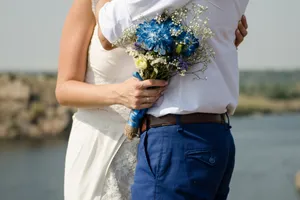 Happy bride in park with bouquet