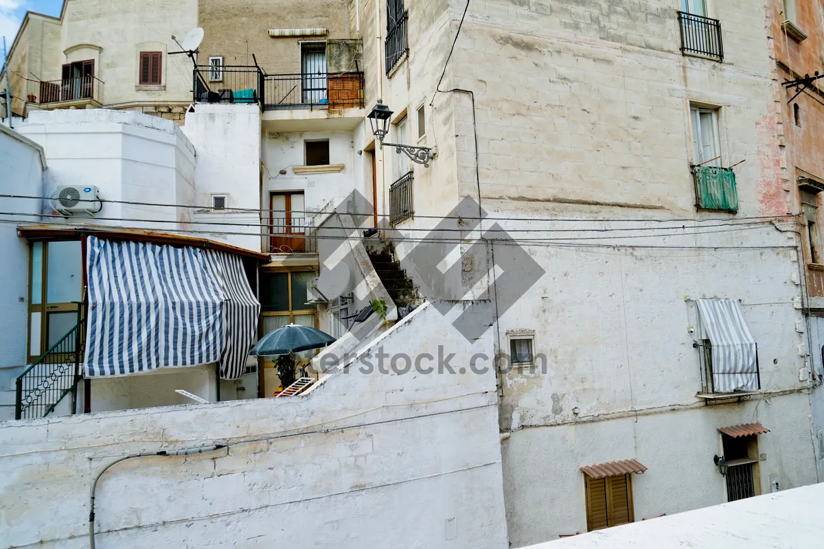 Picture of Old stone building with air conditioning unit on balcony.