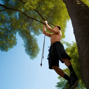 Active Park Lifestyle: Happy Man Swinging in Summer
