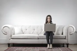 Happy adult sitting on modern leather sofa