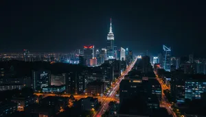 City skyline at night with illuminated buildings and ships