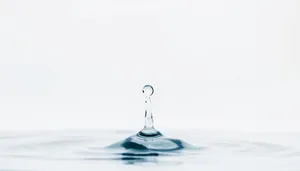 Clear wine glass with water drops splashing