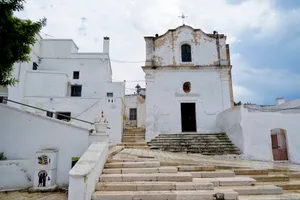 Historic church with bell tower against city skyline.