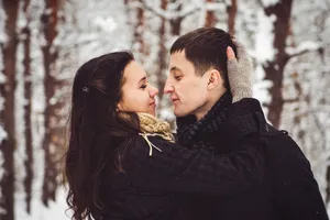 Happy couple smiling outdoors in romantic embrace.