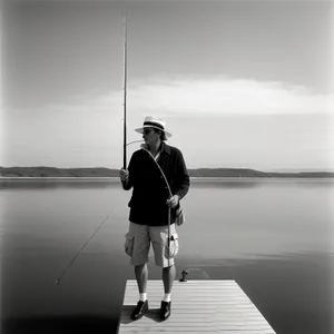 Sunset Fisherman Reeling in Catch on Beach