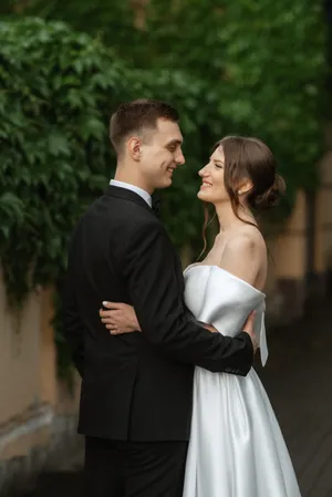 Happy couple in park on wedding day with flowers