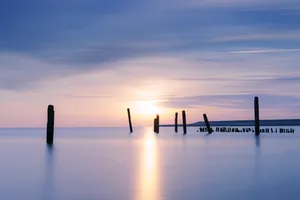 Sunset silhouette city skyline reflection over water beach.