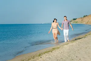 Happy couple on tropical island beach shore.