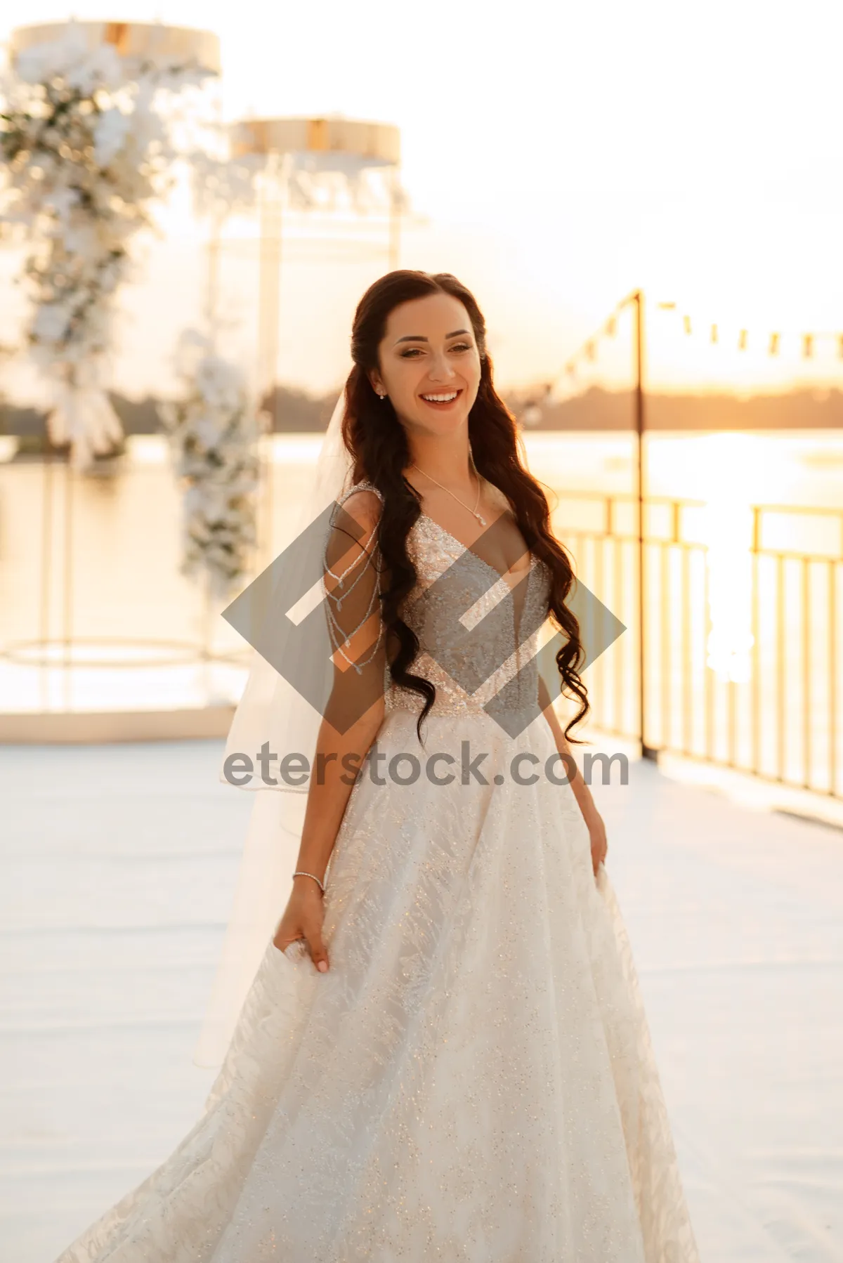 Picture of Elegant brunette bride in princess dress smiling happily.