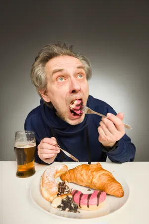 Happy man enjoying breakfast with coffee and juice