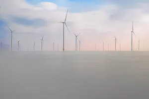 Renewable energy wind turbines against a cloudy sky landscape