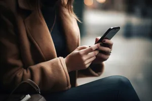 Business person writing notes with a pen and phone