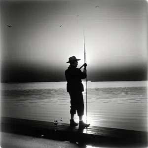Silhouetted Fisherman Enjoying Sunset by the Beach