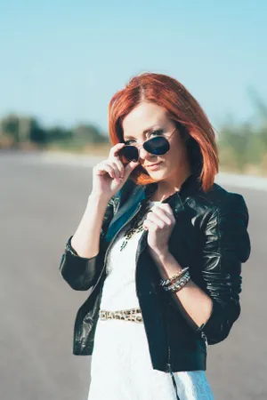 Attractive singer in sunglasses talking on phone.