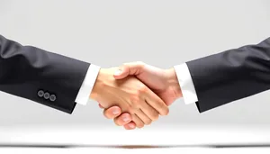 Happy adult in business attire smiling and shaking hands.