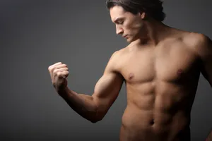 Muscular male model posing shirtless in studio portrait