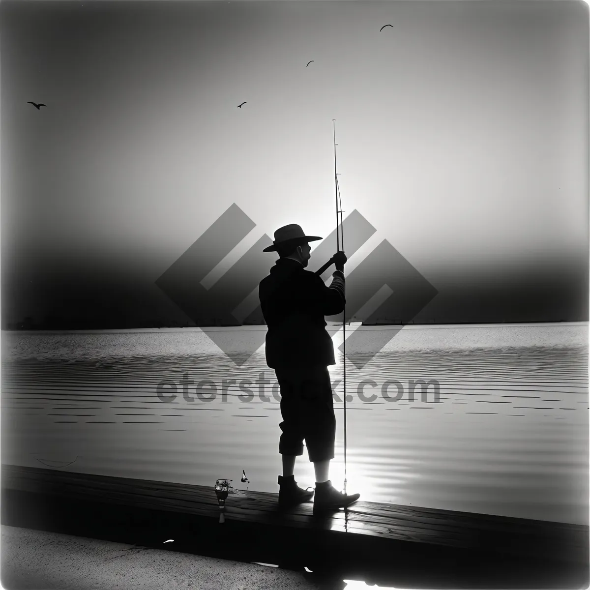 Picture of Silhouetted Fisherman Enjoying Sunset by the Beach