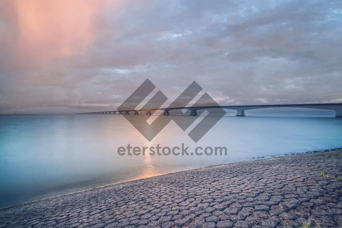 Picture of Relaxing sunset on tranquil beach overlooking ocean shore.