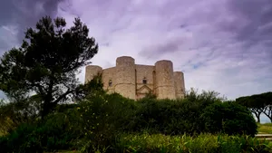 Medieval castle tower against scenic historic landscape.