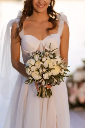 Happy Bride in Wedding Dress with Flower Bouquet