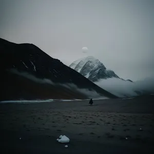 Serene Coastal Sunset over Majestic Mountains