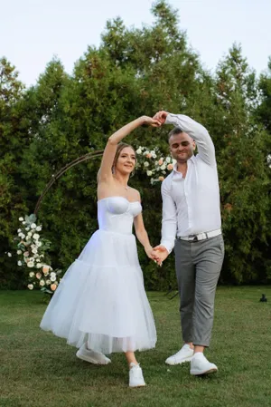 Happy bride and groom celebrating in park