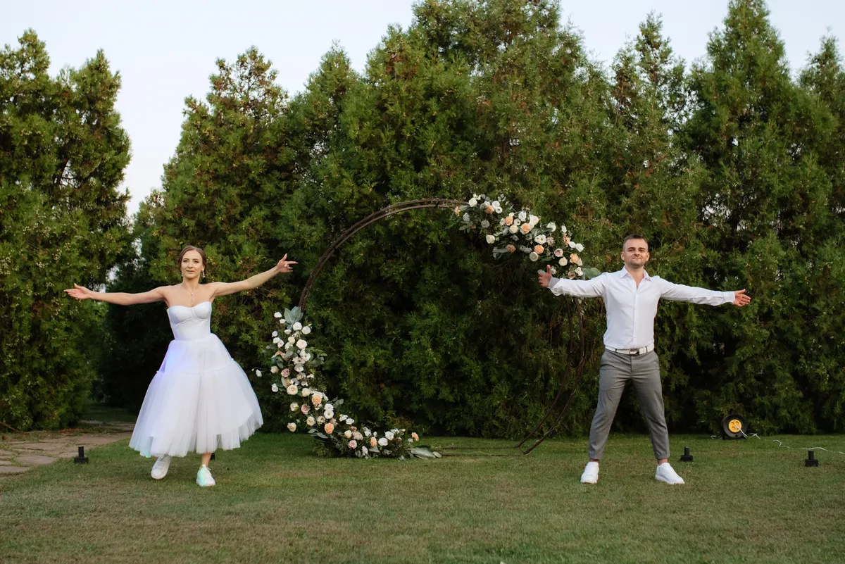 Picture of Happy groom playing badminton with bride in the park.