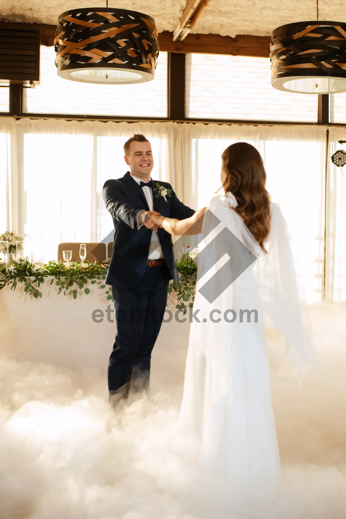 Picture of Happy couple celebrating wedding day with bouquet of flowers.